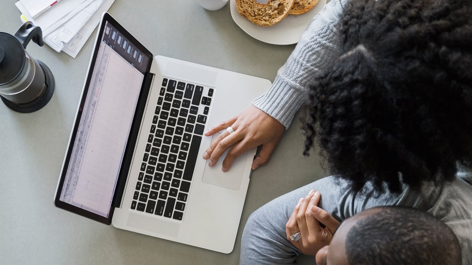 A woman using a laptop sitting closely to a man.