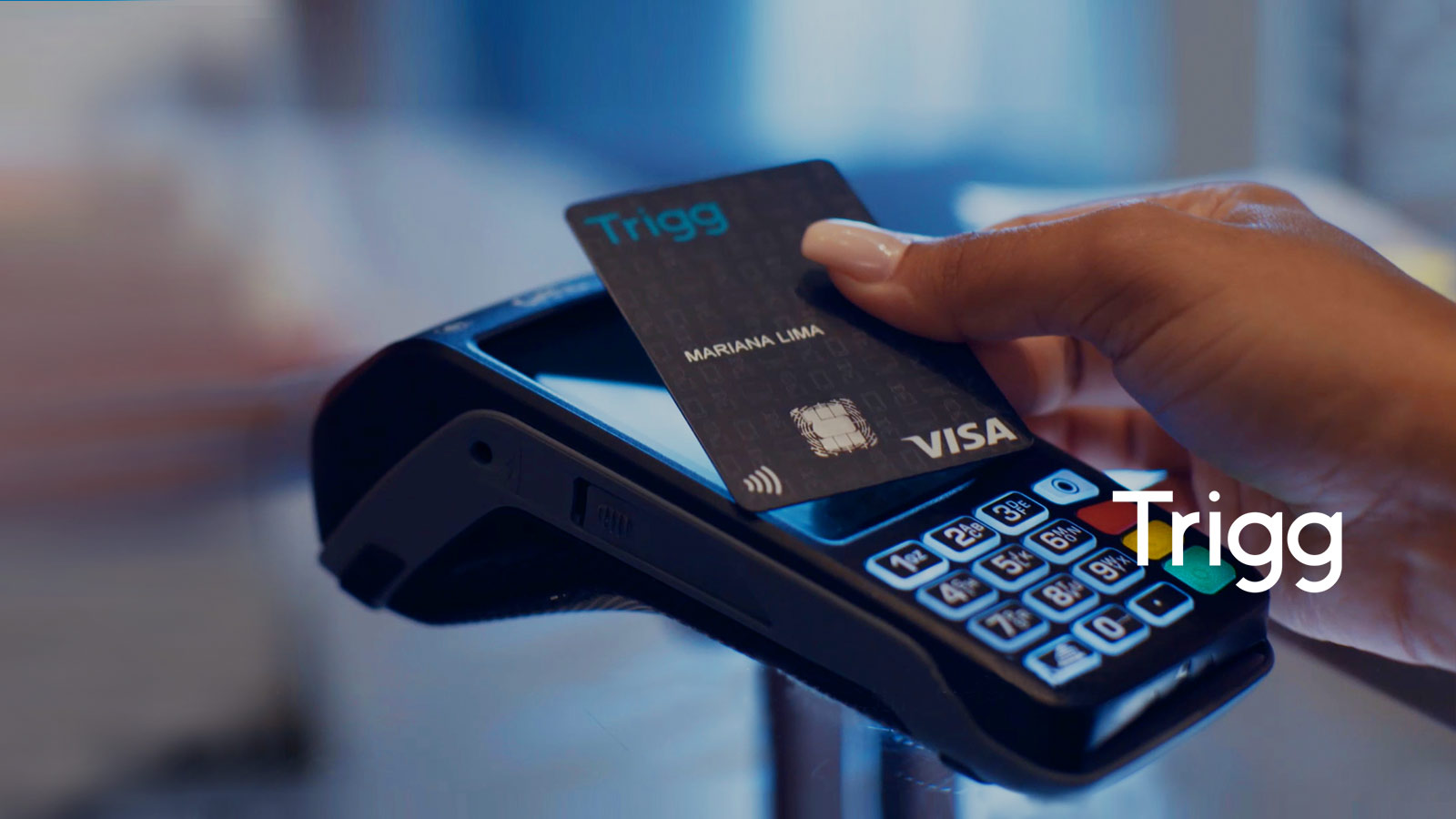 Close up of a person using a Visa card with a Trigg logo on it to make a point of sale transaction.