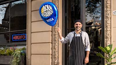 Cocinero sosteniendo el globo de Visa #AquíEstamos