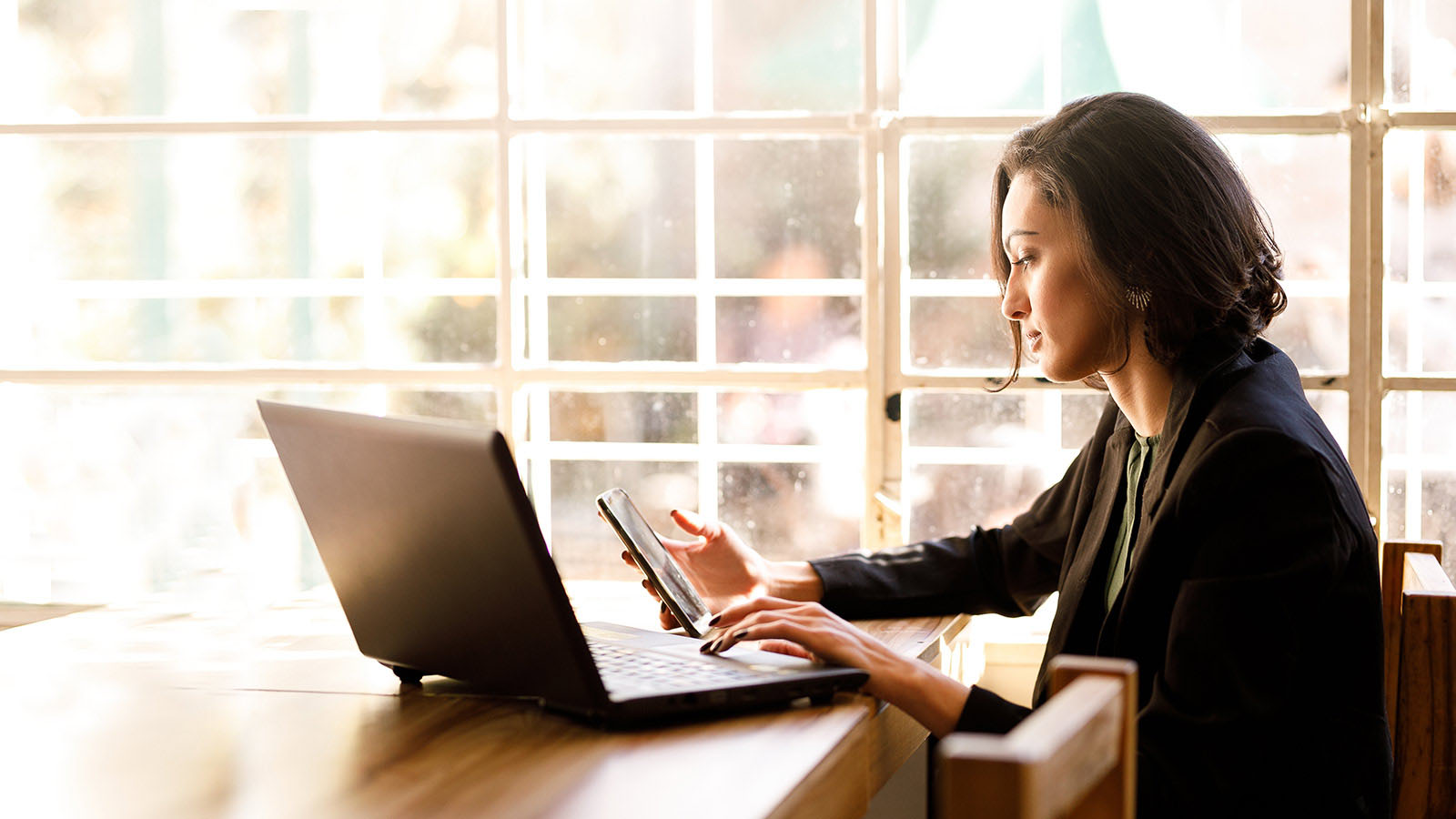 mujer empresaria trabajando con móvil y laptop