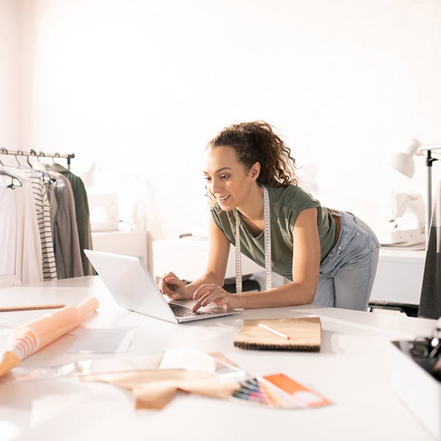 Mujer costurera haciendo trabajos en su notebook