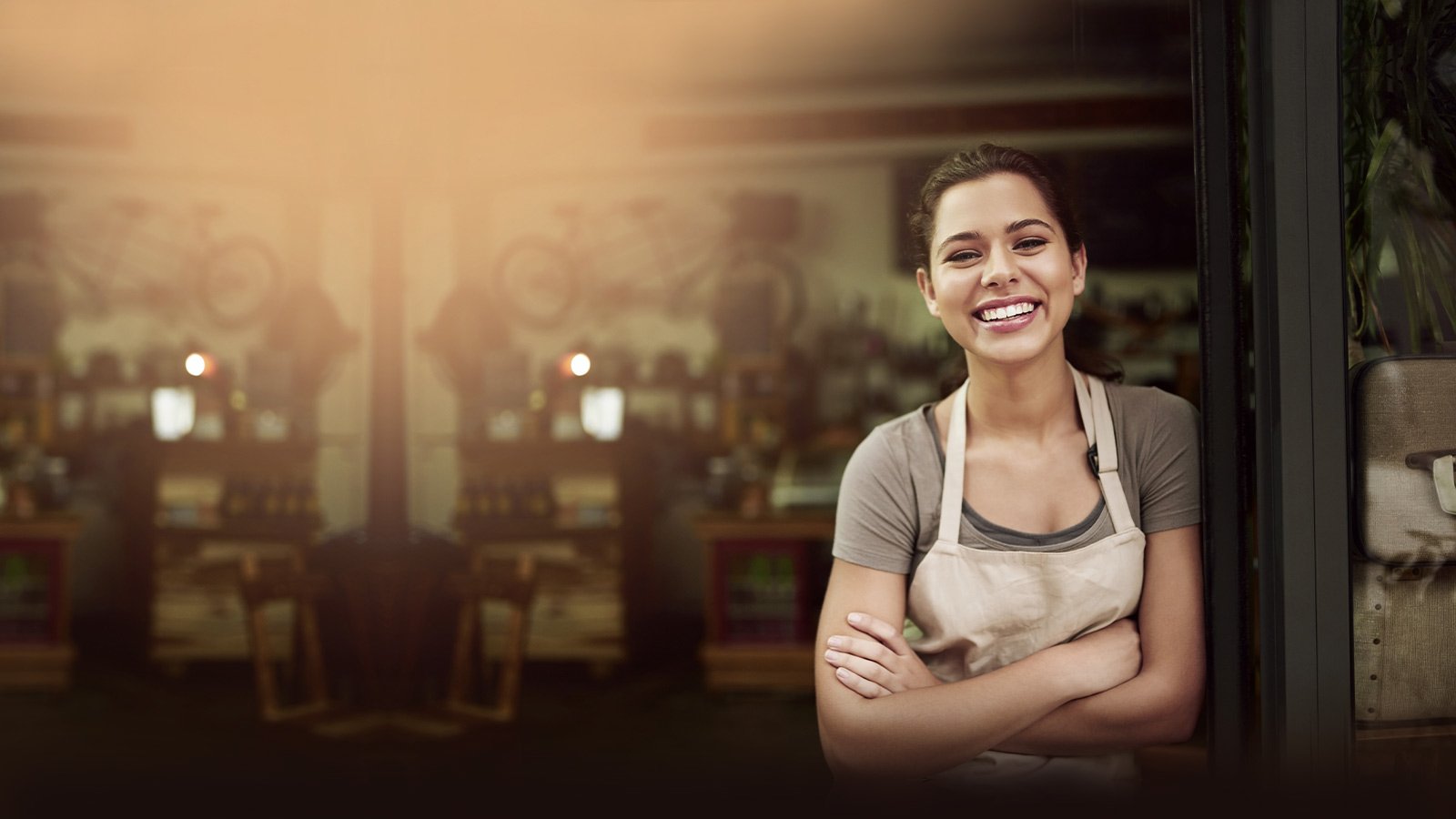 Mujer sonriente en la entrada a su comercio