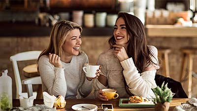 Mujeres sonrientes compartiendo un desayuno 