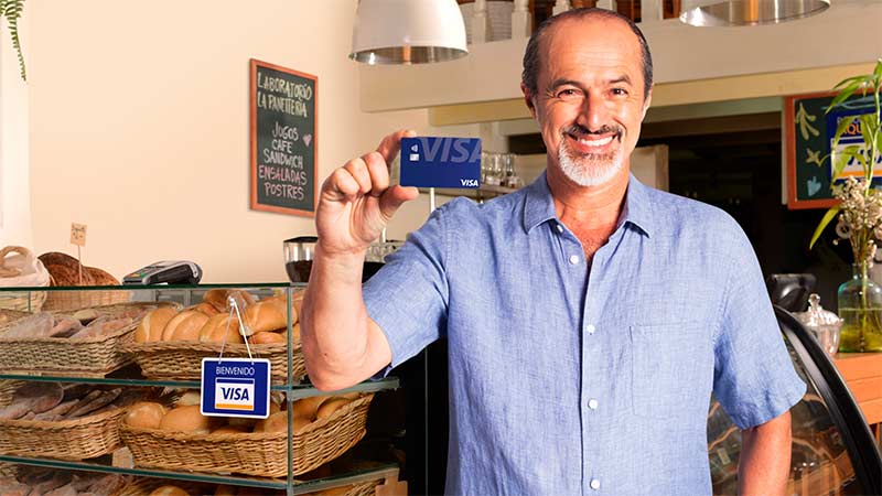 Hombre sonriente sosteniendo tarjeta Visa